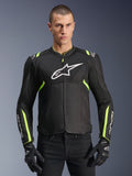 Alpinestars T-Sps Air V2 Jacket in Black Yellow Fluo, male model wearing the ventilated textile jacket with mesh panels and white chest logo, paired with black riding gloves, urban motorcycle gear