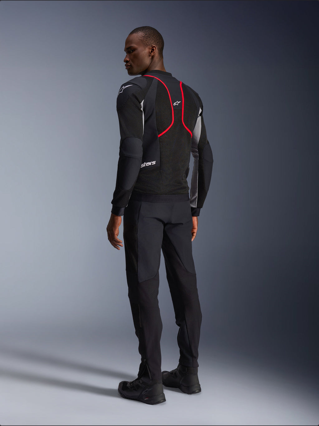 Alpinestars Troop-Air Pro Jacket, Motorcycle Jacket, Black Ash Gray and Bright Red, back view on model, featuring red accent lines and mesh ventilation panels, worn with black pants and boots, urban motorcycle style