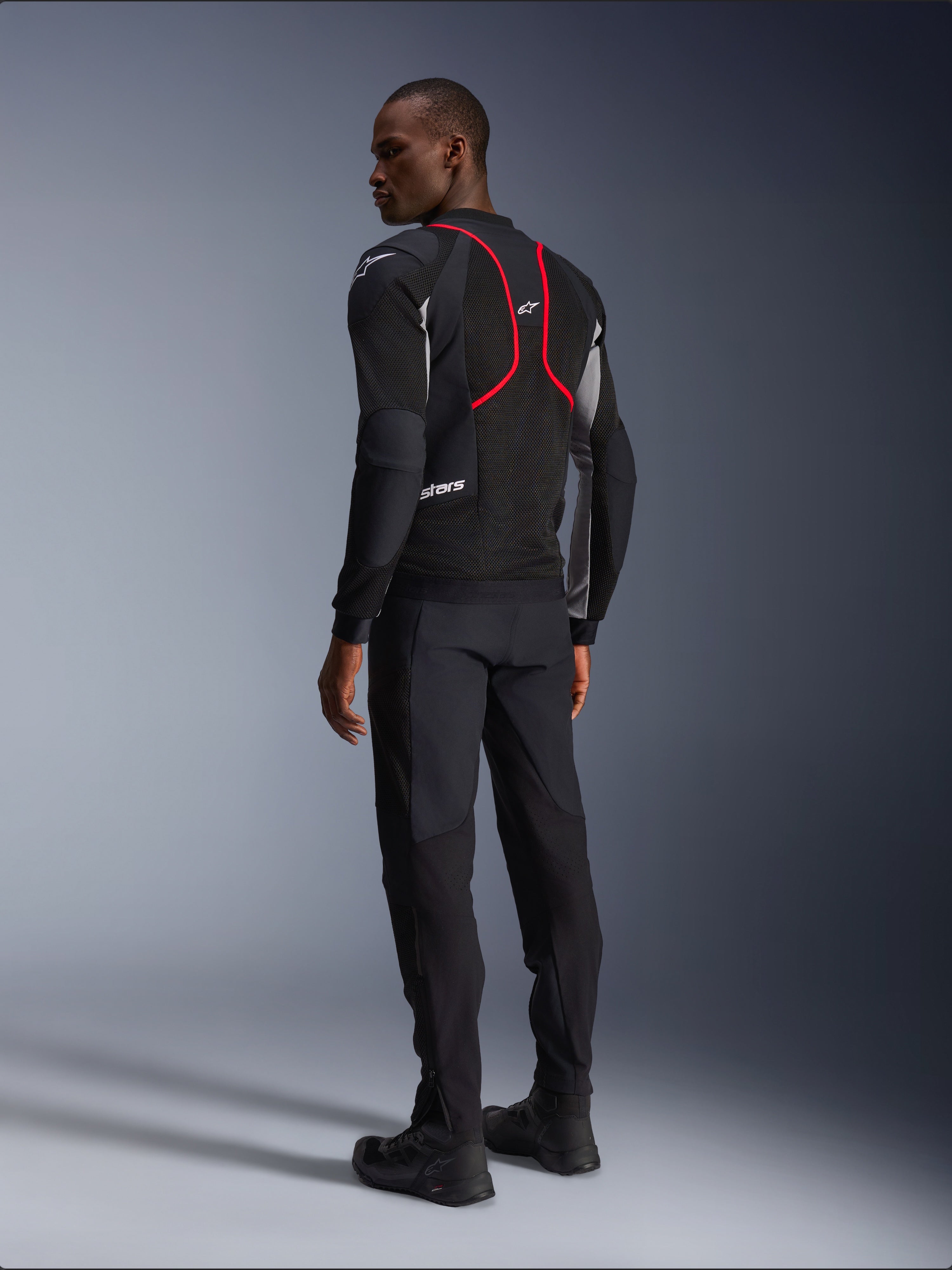 Alpinestars Troop-Air Pro Jacket, Motorcycle Jacket, Black Ash Gray and Bright Red, back view on model, featuring red accent lines and mesh ventilation panels, worn with black pants and boots, urban motorcycle style