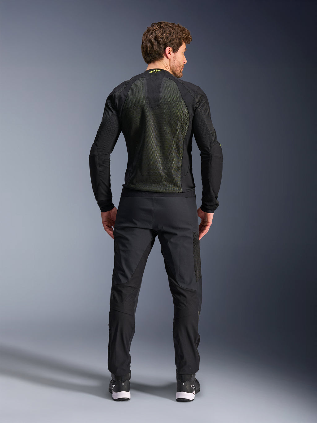 Alpinestars Troop-Air Jacket, Black Yellow Fluo, back view on a model, featuring a large 2D tech mesh back panel for ventilation, technical motorcycle jacket worn with black riding pants and boots, urban motorcycle style
