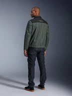 Alpinestars Ignite Air Jacket in Urban Gray Black Blue, rear view on model, featuring a mesh body with a black shoulder yoke and white text, striped cuffs, paired with dark denim jeans and black sneakers, urban lifestyle motorcycle apparel