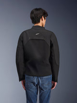 Alpinestars Provoke Jacket, Urban Motorcycle Jacket, Black, rear view showing white Astars logo and technical ripstop panels, worn with blue denim jeans, contemporary design for city commuting