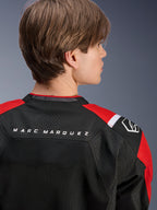 Alpinestars MM93 T-SPS Air V2 Jacket, rear view of the upper back and shoulders, Black with Bright Red and White details, 'MARC MARQUEZ' text across the yoke, featuring technical mesh panels and shoulder logo, urban sport motorcycle apparel