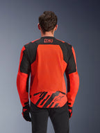 Alpinestars MM93 T-SPS Air V2 Jacket, Rear View, Red Fluo and Black, featuring 93 racing logo on the neck, large mesh panel on the back for airflow, lower back flap with Alpinestars star logo and geometric stripes, worn with black pants and riding gloves