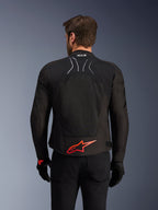 Alpinestars SMX Air Jacket, Rear View, Black with Bright Red Alpinestars logo on the lower back, featuring a high-airflow tech mesh panel and Tech-Air Ready branding, worn by a male rider with black pants and gloves