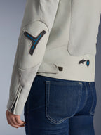 Alpinestars Woman Stella Circal-1 Air Jacket in Metal Gray and Methyl Blue, close-up of the back and sleeve detail showing mesh airflow panels, neon blue accents on the elbow and waist, and adjustable tab, worn with dark blue denim jeans.