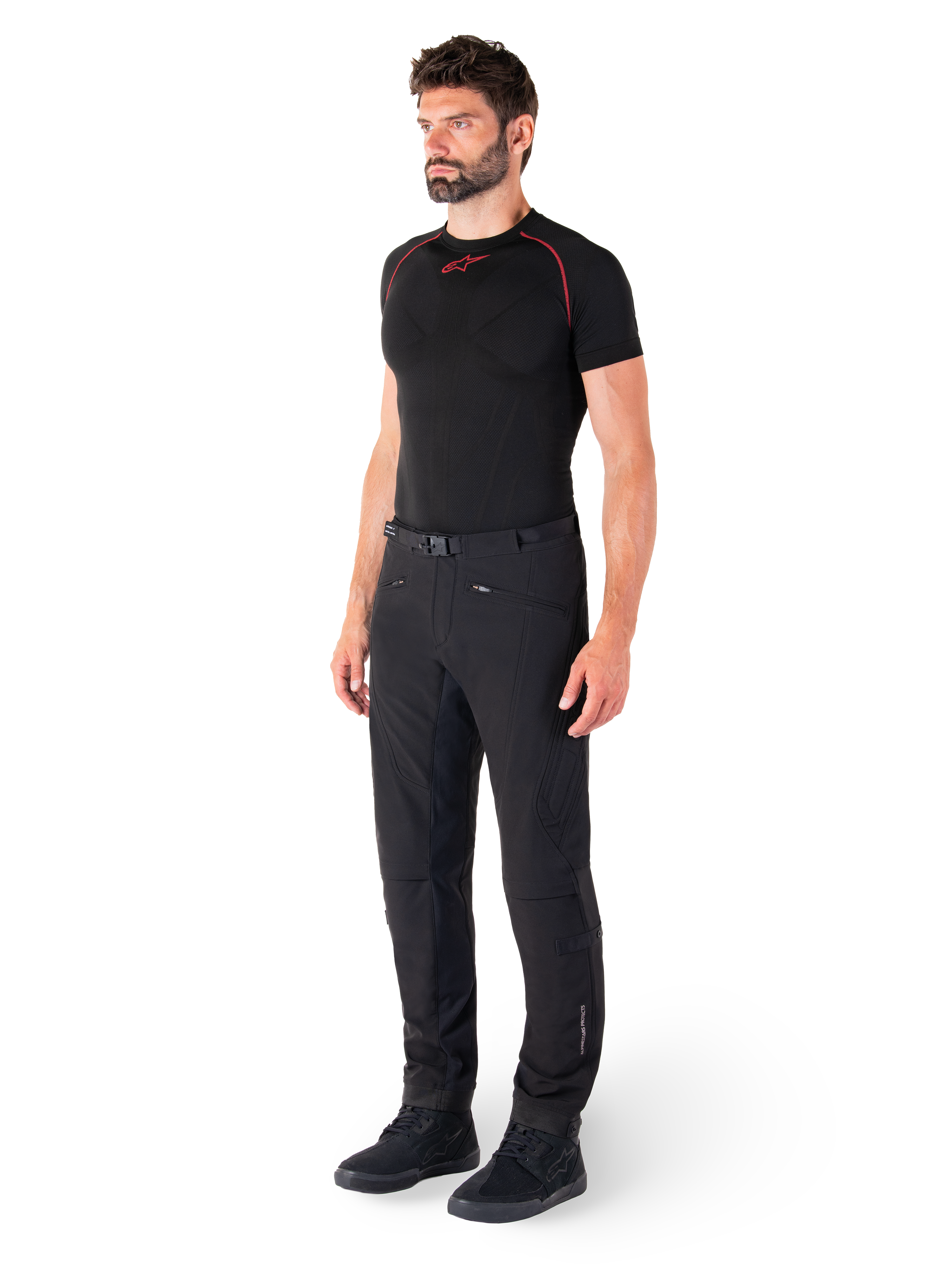 Alpinestars Alden Pants, Urban Motorcycle Pants, Black, regular fit softshell textile, worn by a model with a black base layer and riding shoes, featuring a waist belt with magnetic closure and zippered pockets.