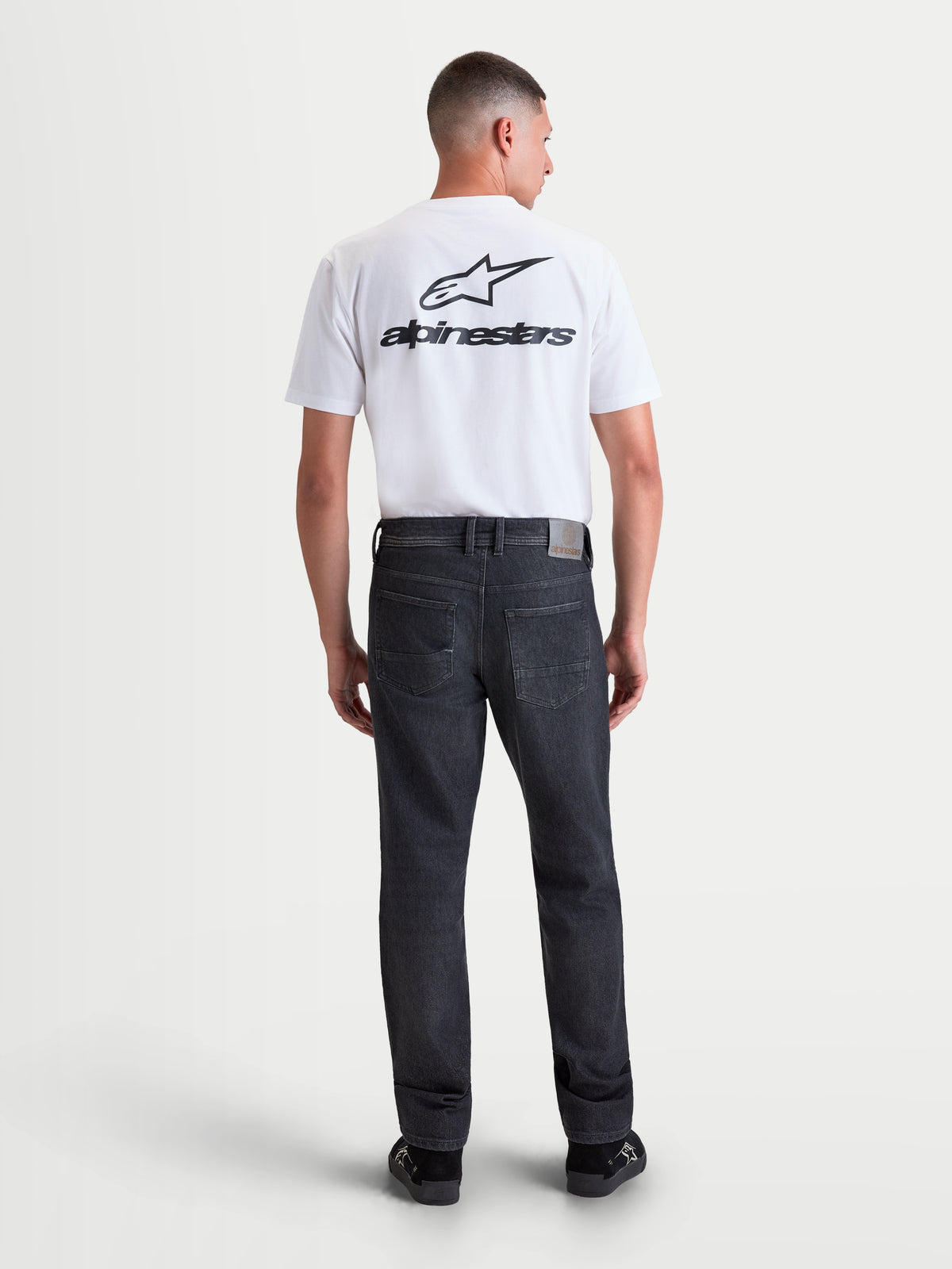 Alpinestars Flex-AST 8 Denim Pants, men's urban contemporary motorcycle riding jeans in Used Black, rear view on a model wearing the AA-rated single-layer denim with a leather back patch and back pocket embroidery