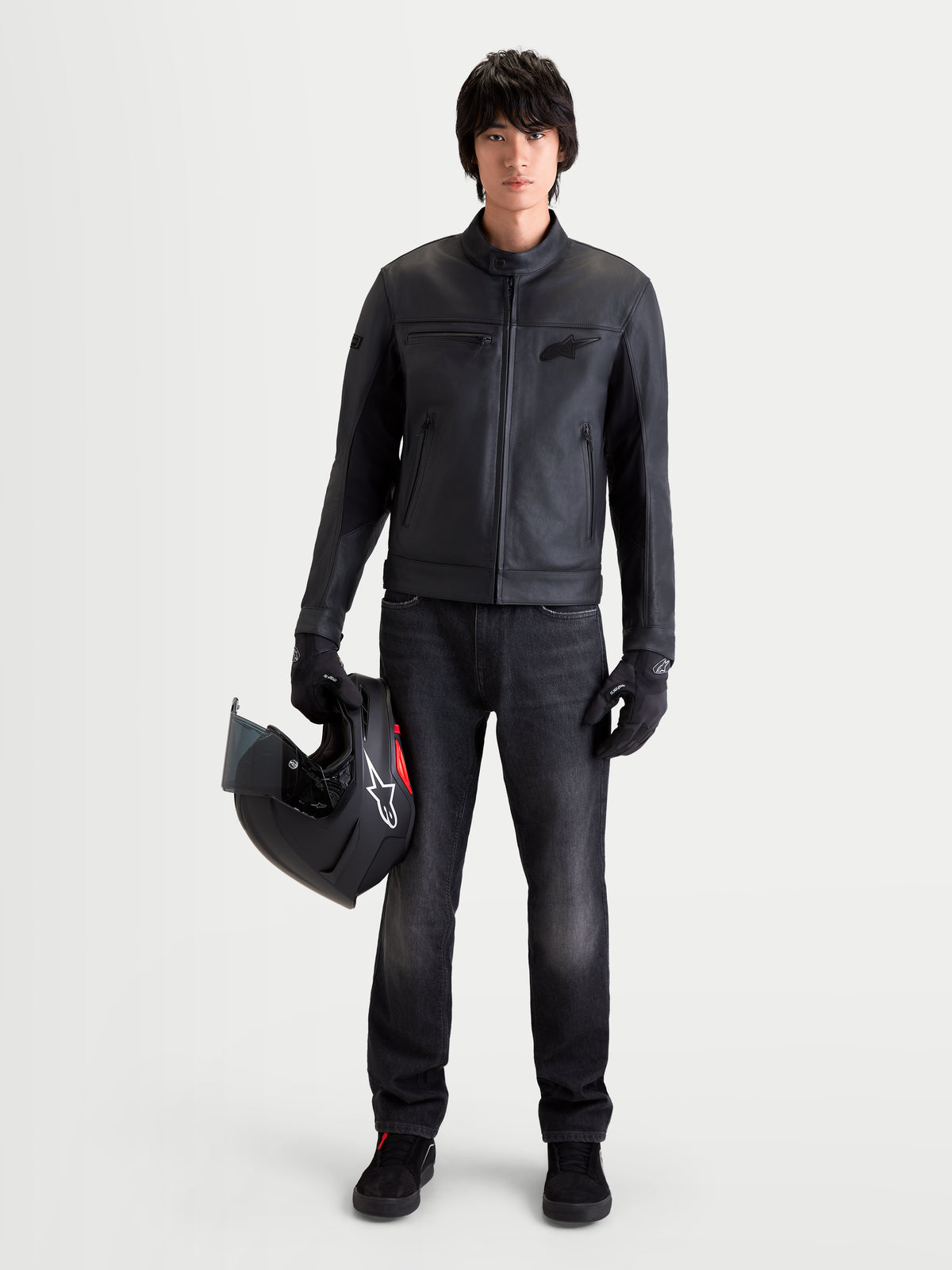 Alpinestars Flex-AST 7 Denim Pants, men's urban motorcycle riding jeans in faded black, worn by a model holding a helmet and matching apparel