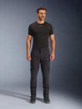 Alpinestars Flex-AST Explorer Pants, Black adventure touring motorcycle pants, man wearing fitted textile riding pants with zippered cargo pockets and reinforced panels, styled with a black base layer and motorcycle boots, durable protection for adventure riding