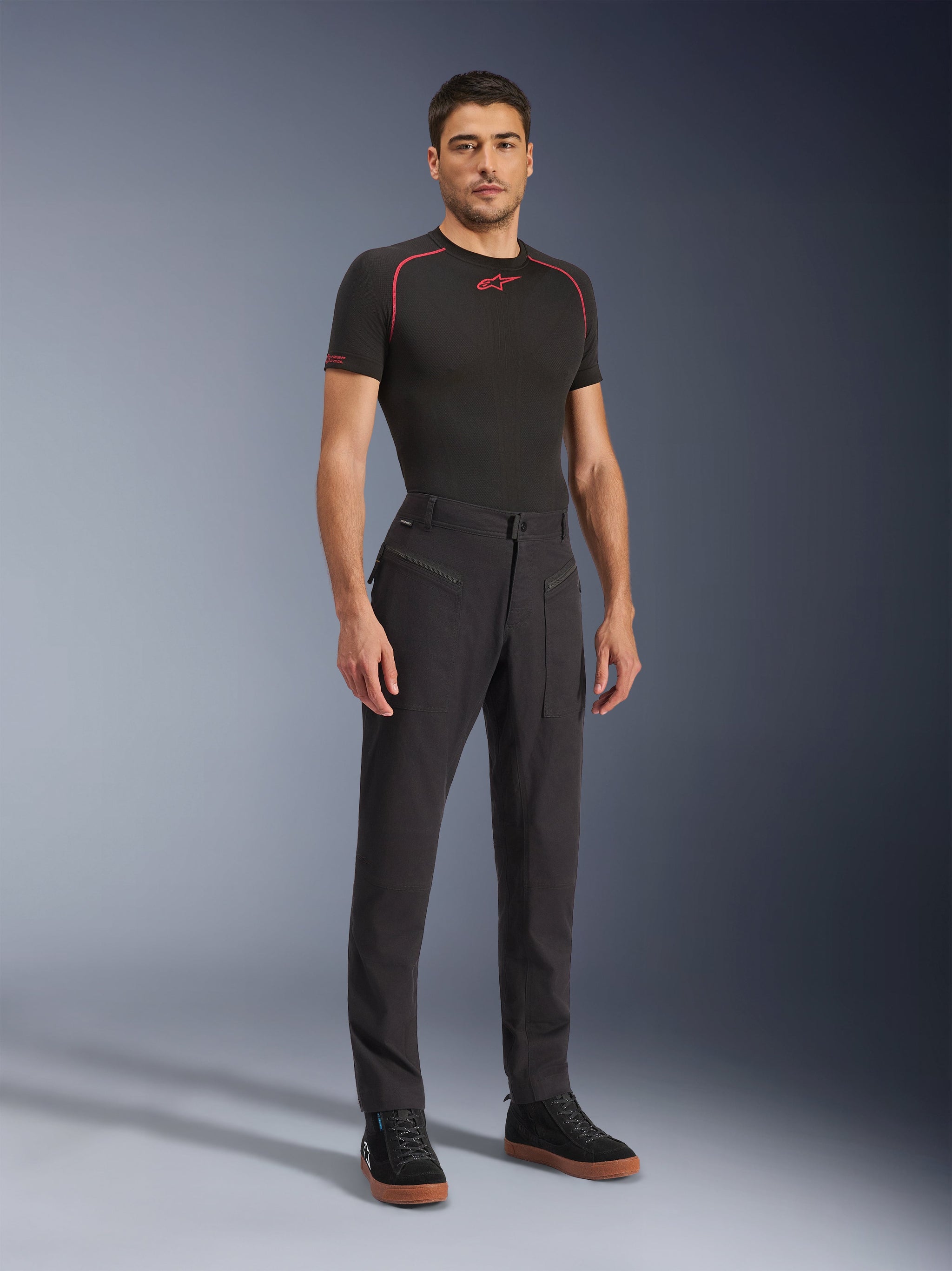Alpinestars Flex-AST Canvas Pants, Urban Motorcycle Pants, Black, worn with a black base layer and casual high-top sneakers, featuring large zipper utility pockets and a workwear-inspired design with an ergonomic fit for riding