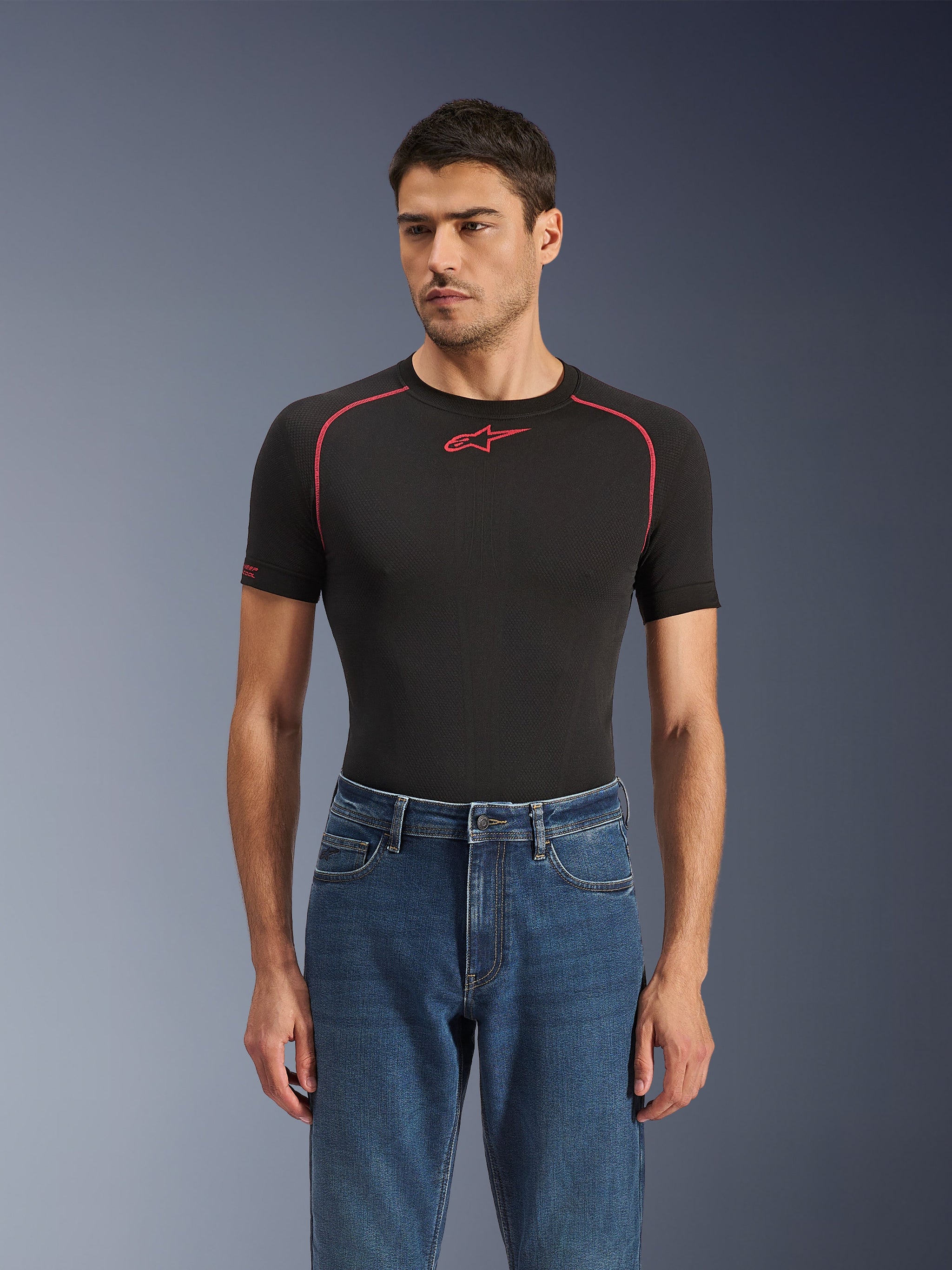 Alpinestars Flex-AST 5 Denim Pants in Indigo Washed, urban motorcycle jeans with a tapered fit, worn by a male model with a black short-sleeved base layer featuring red accents, casual road-to-street styling