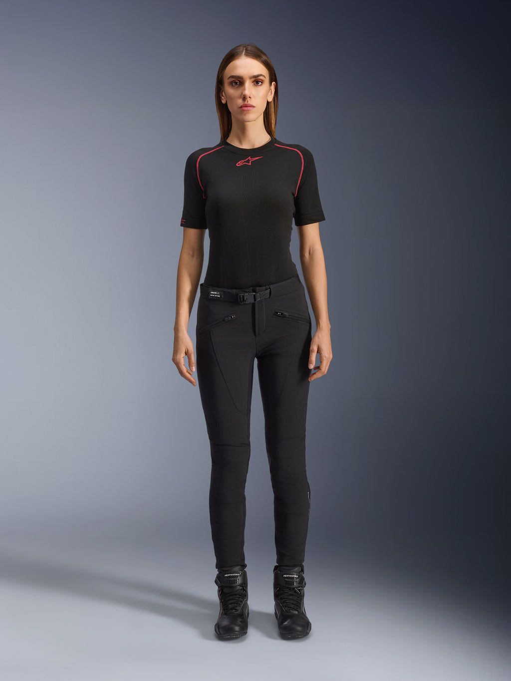 Alpinestars Alamosa Women Pants, slim-fit black motorcycle riding pants, shown on a model facing forward, featuring zippered front pockets and an integrated waist belt, minimalistic streetwear-inspired style for urban riding