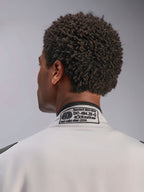 Alpinestars GP Race V3 Suit FIA, Silver Anthracite, close-up of the back collar featuring the embroidered FIA 8856-2018 certification label, detailing safety compliance for auto racing gear
