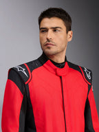 Male model wearing Alpinestars GP Pro Comp V2 FIA Auto Racing Suit, Red and Black, featuring white Astars logos on shoulders and silicon grip technology detailing, professional motorsport apparel