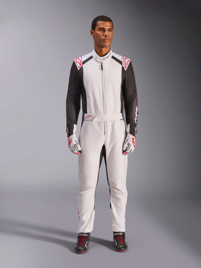 Alpinestars KMX-5 V3 Suit, one-piece karting suit, White Black and Bright Red, worn by a model with matching racing gloves and shoes, professional motorsport gear for competitive go-kart driving.