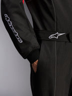 Alpinestars KMX-9 V3 Suit, Karting Suit, Black Red and White, close-up detail of the adjustable waist belt with star logo and sleeve with embroidered branding, featuring white contrast stitching and a side pocket.