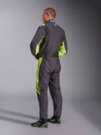 Alpinestars KMX-9 V3 Graphic 3 Suit, Karting Suit, Black and Yellow Fluo, back view of model showing the one-piece design with fluorescent yellow accents on the sides and underarms, ergonomic stretch panels on the lumbar area, and adjustable waist belt, worn with coordinating racing shoes.