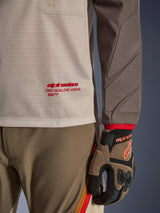 Alpinestars Maxdura Dual Jersey in Aluminum Walnut, detailed view showing the ventilated mesh torso with red branding, abrasion-resistant sleeve with integrated padding, worn with coordinated adventure riding pants and gloves