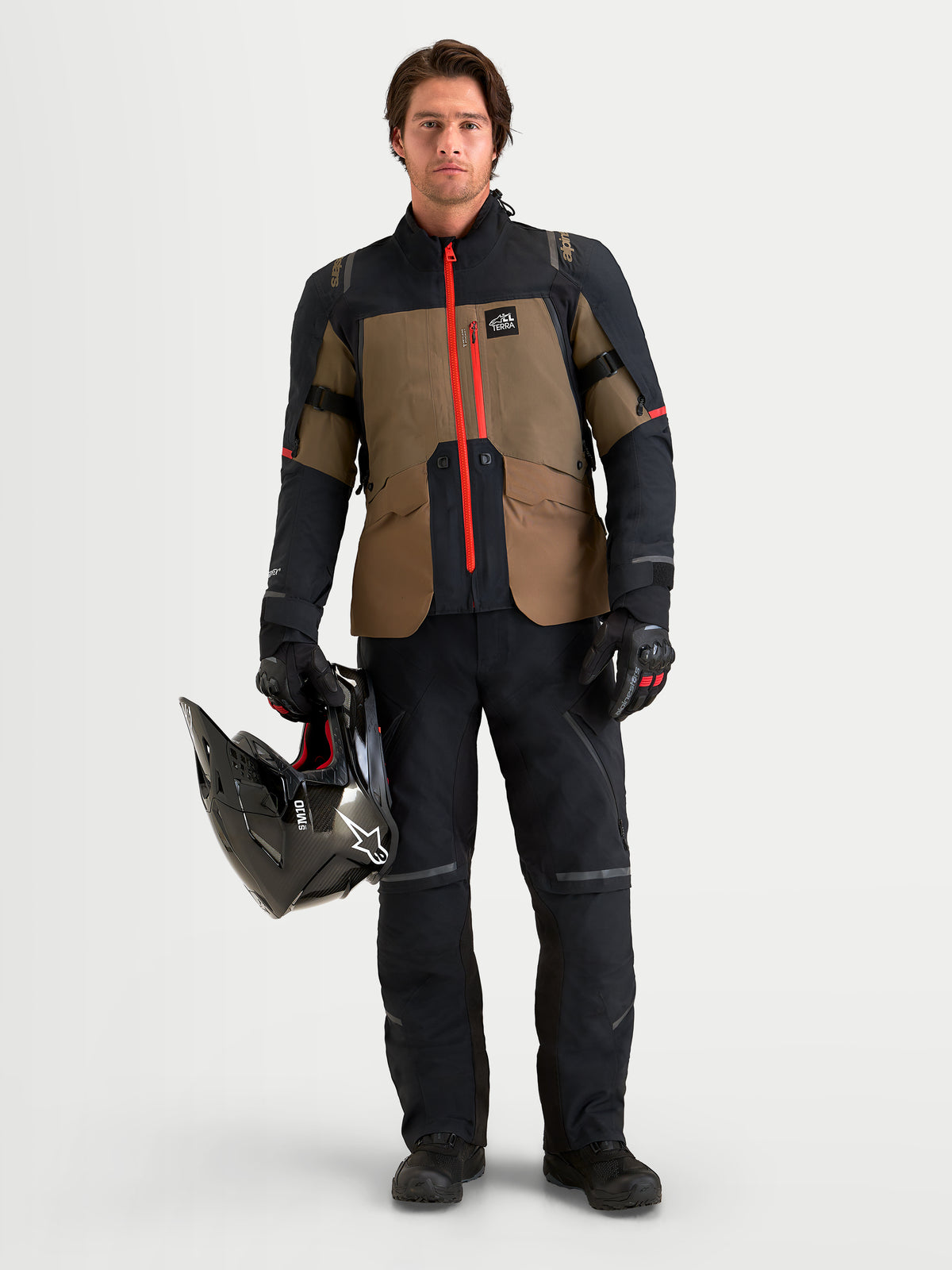 Alpinestars St-7 V2 2L Gore-Tex Jacket, Men's adventure touring motorcycle jacket, Walnut and Black with red zipper details, worn by a male model holding a helmet
