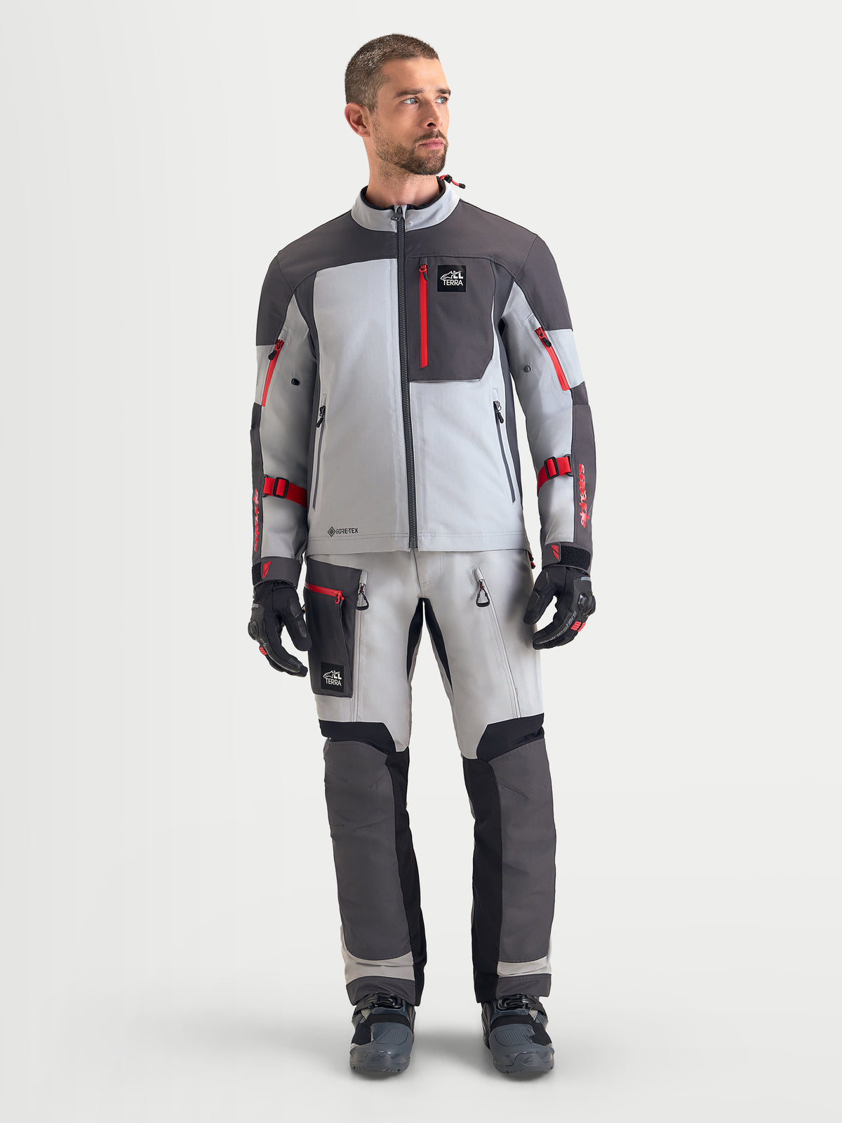 Alpinestars Arenis Gore-Tex® Gear Set, men's adventure touring motorcycle jacket and pants in light gray, dark gray, and red, front view on a model wearing waterproof all-terrain riding apparel