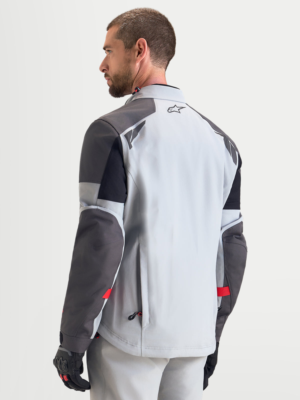 Alpinestars Arenis Gore-Tex® Jacket, men's adventure touring motorcycle jacket in mid gray, deep gray, and black, rear view showing waterproof textile construction and reflective shoulder details.
