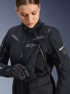 Alpinestars Women Stella ST-7 2L GORE-TEX Jacket in Black Dark Gray, detailed view of the chest ventilation panel open to reveal mesh lining, featuring the Alpinestars logo and shoulder branding, designed for adventure road-touring.