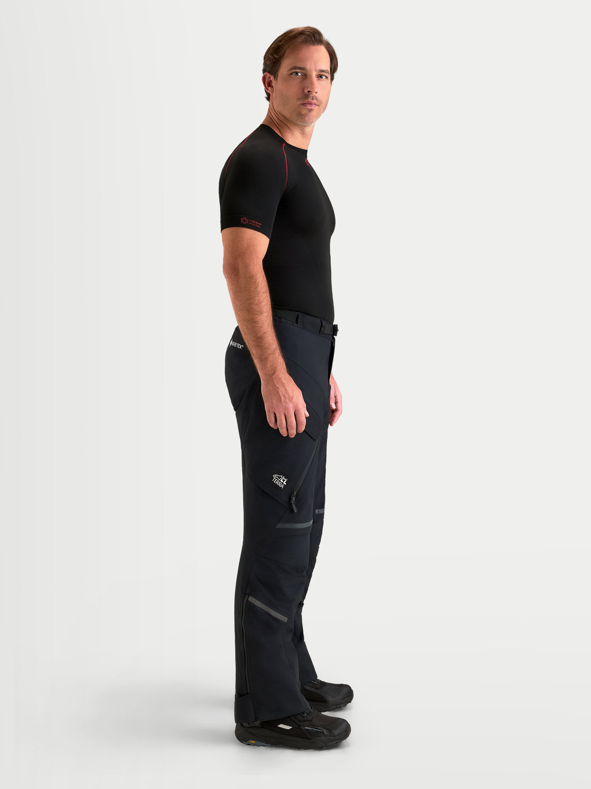Alpinestars St-7 V2 2L Gore-Tex Pants Short, men's adventure touring motorcycle pants in black, side profile view on a model wearing waterproof textile riding gear