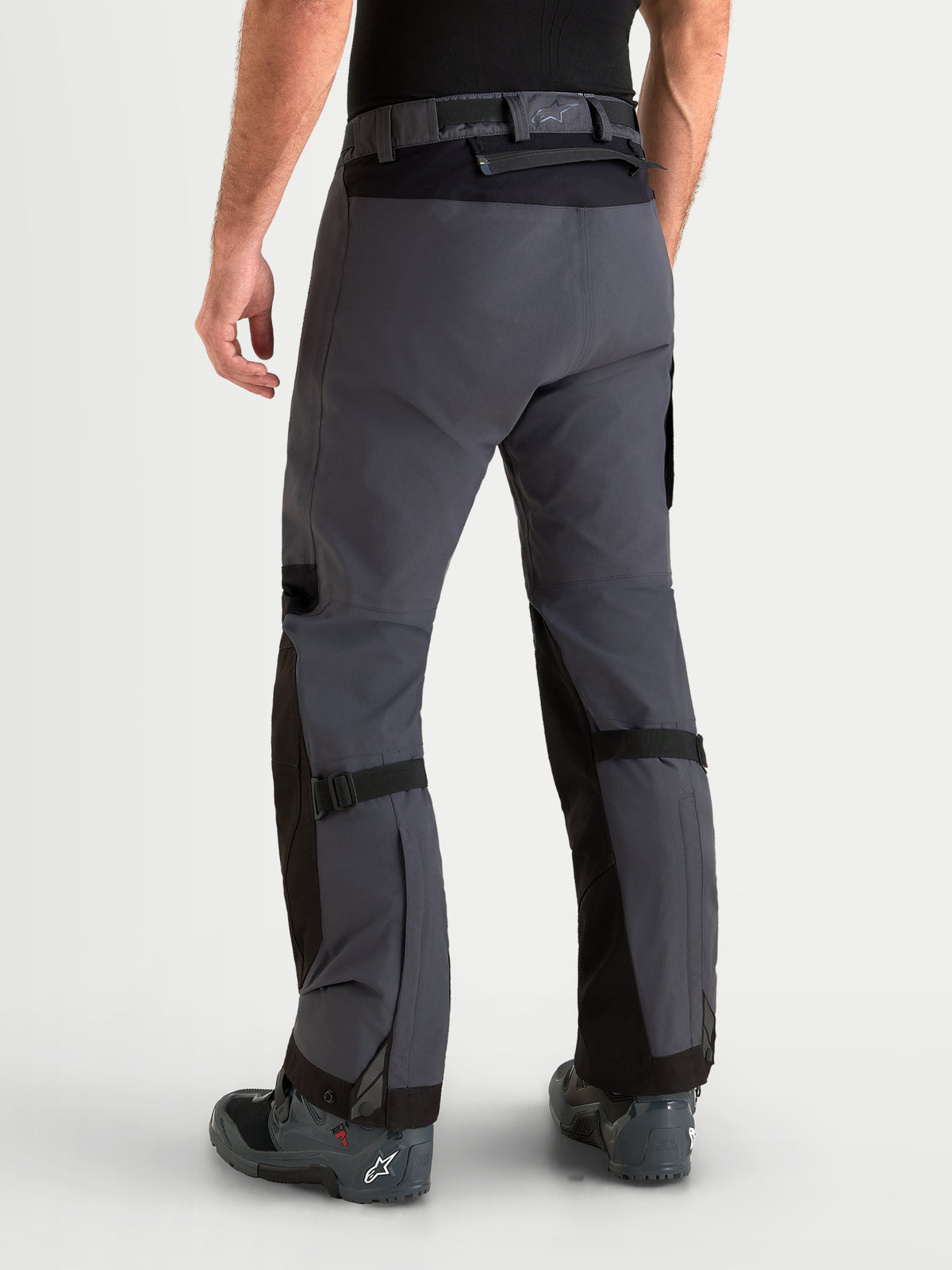Alpinestars Arenis Gore-Tex Pants, men's adventure touring motorcycle pants in black and deep gray, rear profile view on a model showing waterproof textile construction and waist closure.