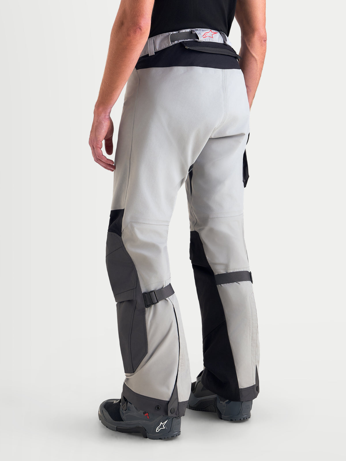 Alpinestars Arenis Gore-Tex Pants, men's adventure touring motorcycle pants in mid gray, deep gray, and black, rear three-quarter view on a model showing waterproof textile construction and reinforced knee and seat zones