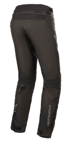 Alpinestars Women Stella Road Pro GORE-TEX Pants, Black, rear three-quarter view, technical textile motorcycle pants with reflective Alpinestars branding on the lower leg, featuring tapered fit, velcro leg adjusters, and waist connection zipper for adventure touring.
