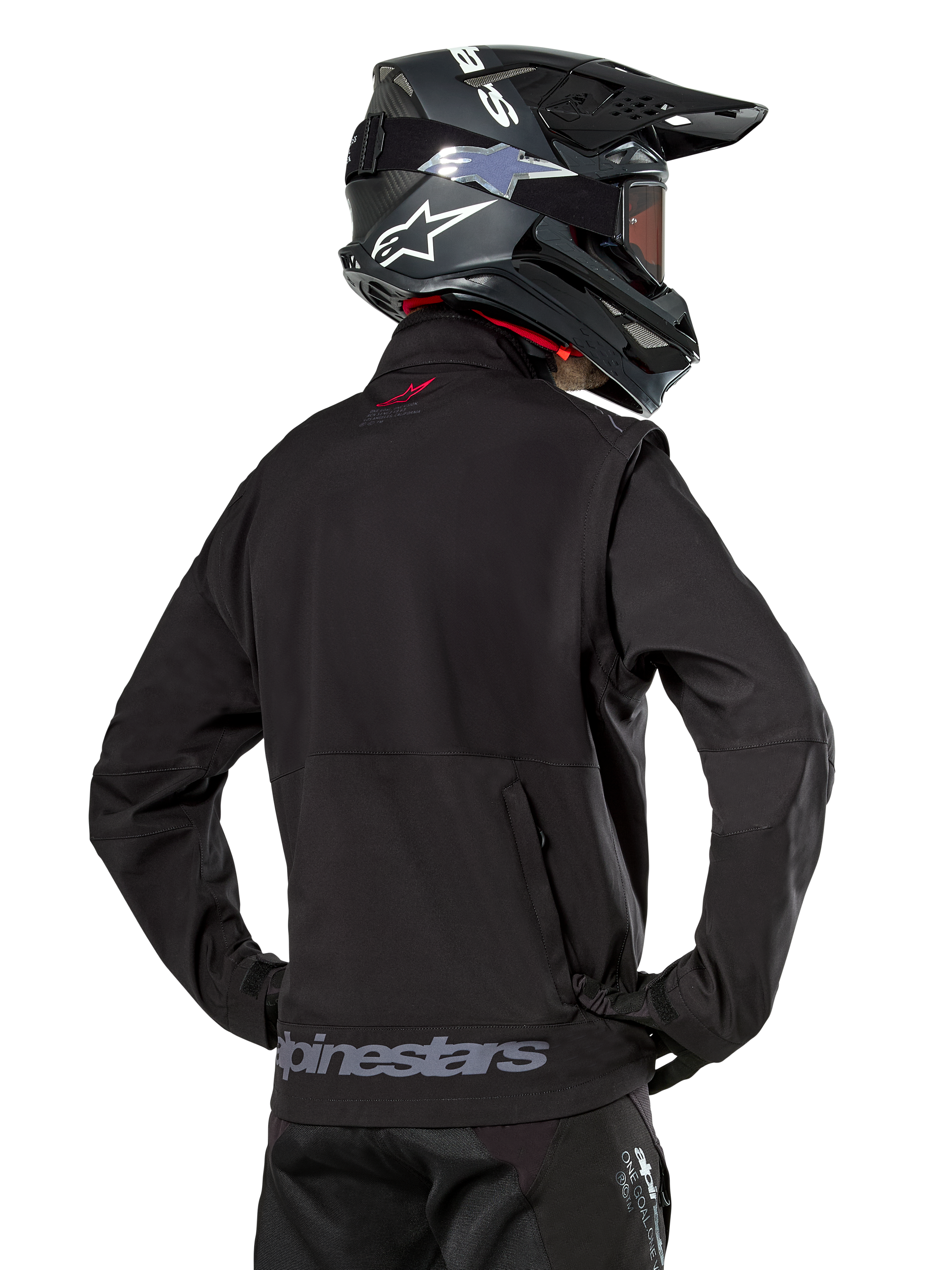 Alpinestars Lite-Dura Softshell Jacket, Black, back view worn by a rider, featuring gray Alpinestars branding on the rear hem and a small red logo on the collar, paired with a black motocross helmet, designed for enduro and off-road riding.