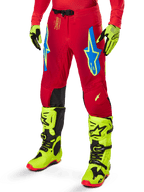 Alpinestars 2025 Supertech Maker Pants, Motocross Racing Pants, Bright Red with blue and yellow star logos, black knee panels, perforated ventilation, coordinated with neon yellow boots and gloves