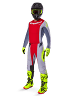 Motocross rider wearing complete racing gear, Red and Gray jersey with Alpinestars branding, 2025 Techstar Melt Pants in Bright Red and Gray with neon yellow accents, bright yellow boots and gloves, black helmet with neon yellow goggles, coordinated outfit for off-road performance.