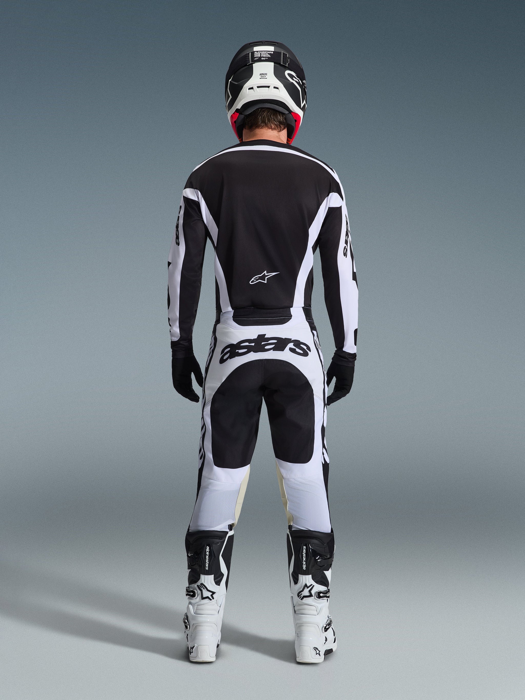 Alpinestars 2026 Racer Riway Pants, Motocross Pants, White and Black, rear view of complete racing gear set, bold 'astars' branding on the seat, worn with matching jersey, white boots, and black helmet, coordinated off-road racing outfit.