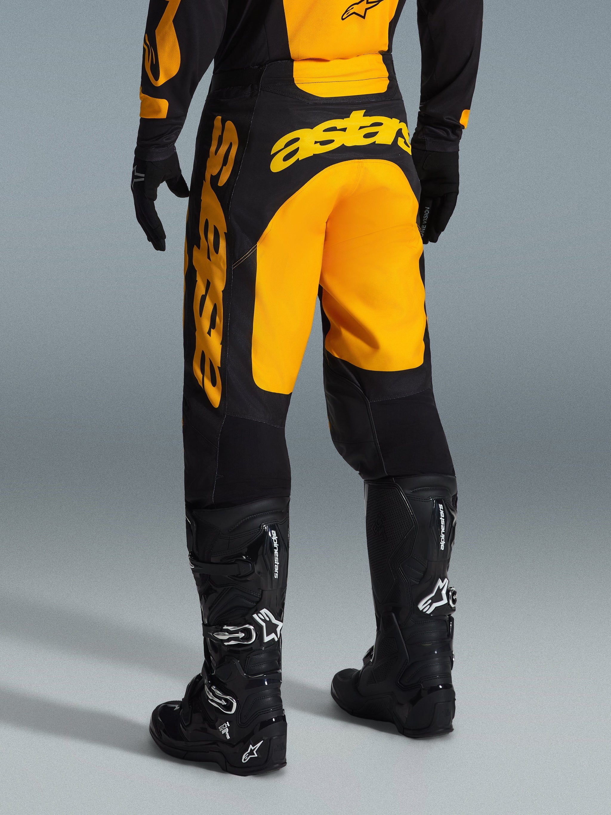 Alpinestars 2026 Racer Riway Pants, Motocross Pants, Yellow and Black, rear view showing bold yellow astars branding across the seat and leg, paired with black motocross boots and gloves