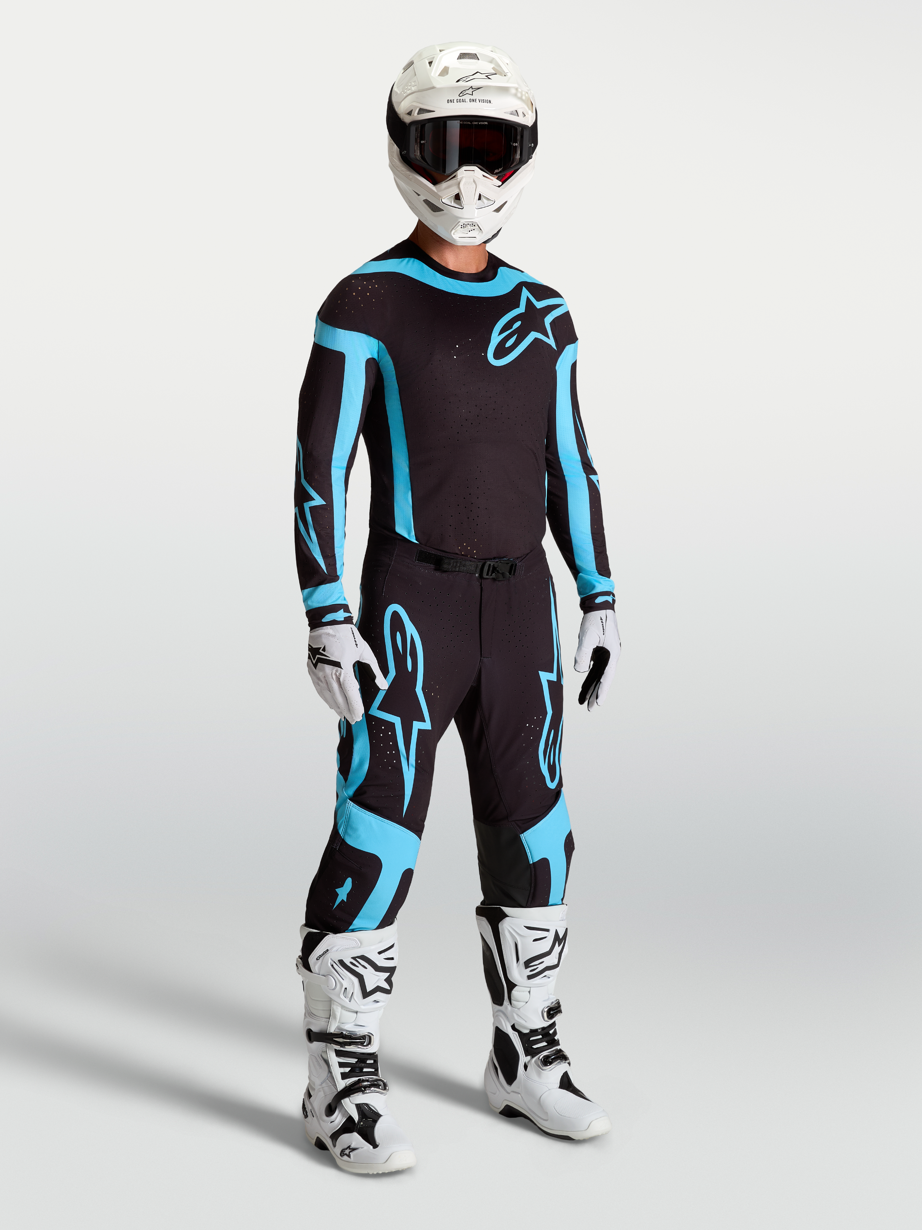 Alpinestars Supertech Vesta Pants, men's black and turquoise motocross racing gear with white boots and helmet.