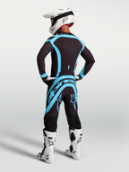 Alpinestars Supertech Vesta Pants, Black and Turquoise professional motocross gear shown from a rear view on model.