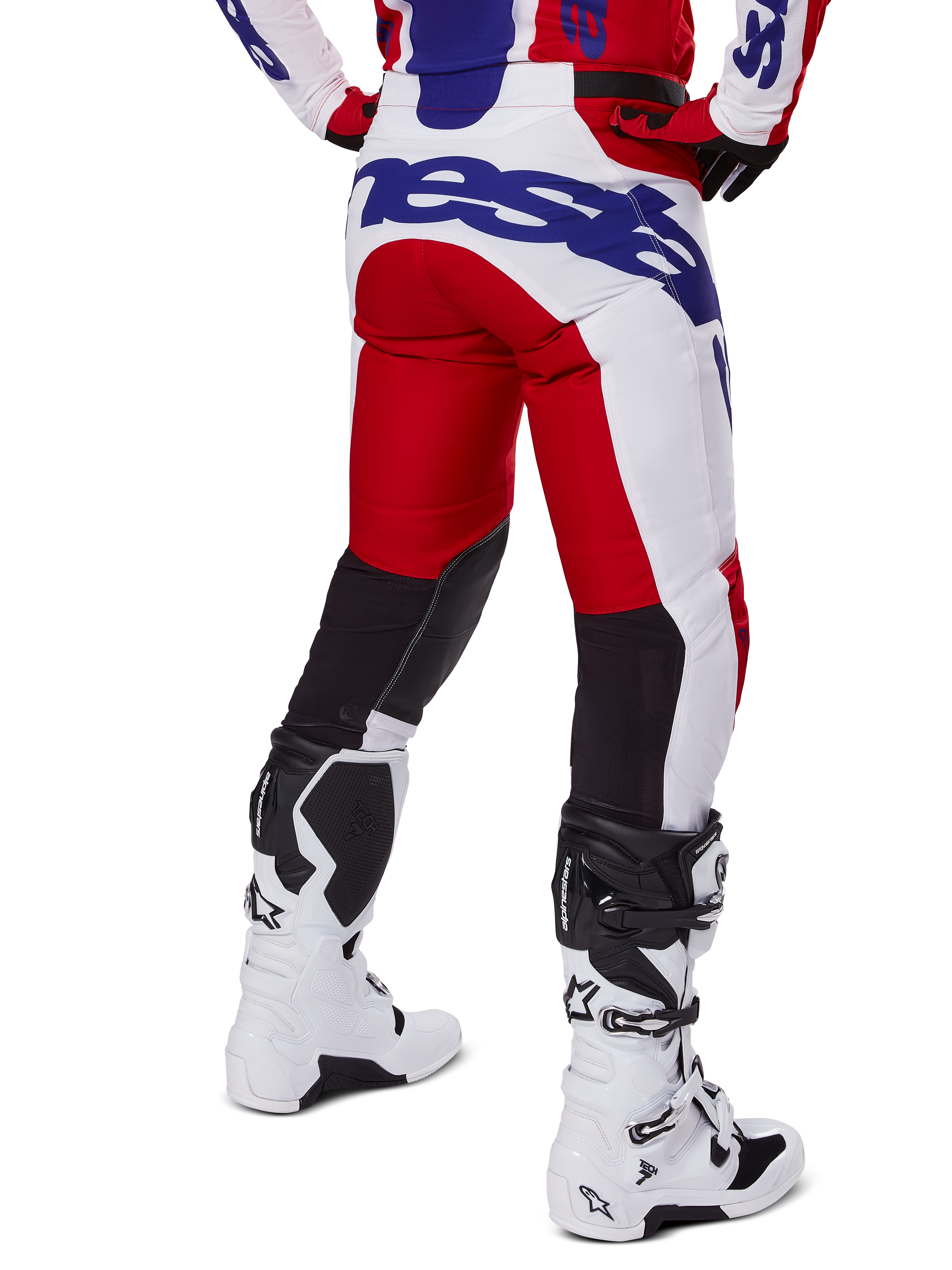 Alpinestars 2025 Racer Veil Pants, Motocross Pants, Bright Red and White with Blue branding, rear view showing black stretch ventilation panels on the back of the legs, paired with white motocross boots.