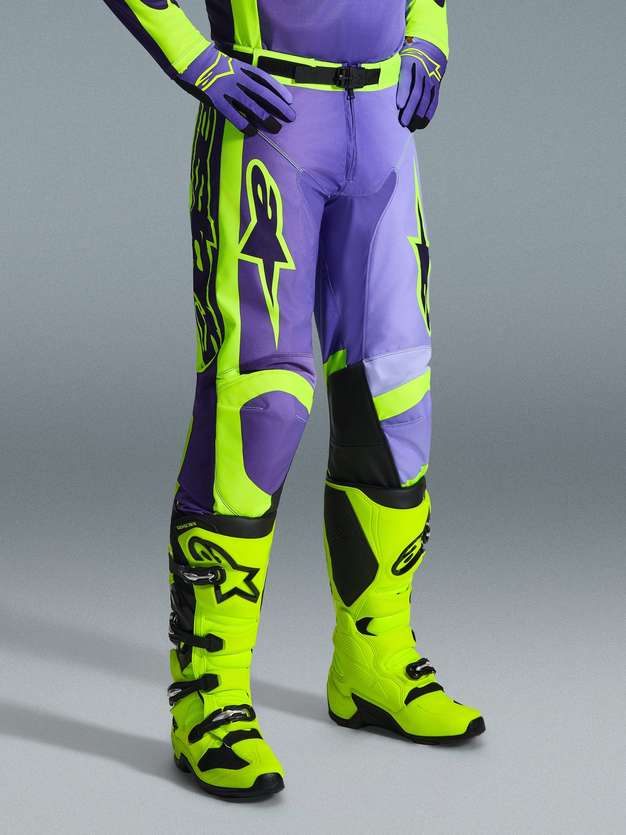 Alpinestars 2026 Racer Portl Pants, Motocross Pants in Purple and Yellow Fluo, worn by a rider with matching fluo yellow boots and purple gloves, featuring bold Alpinestars branding and ergonomic design for off-road performance
