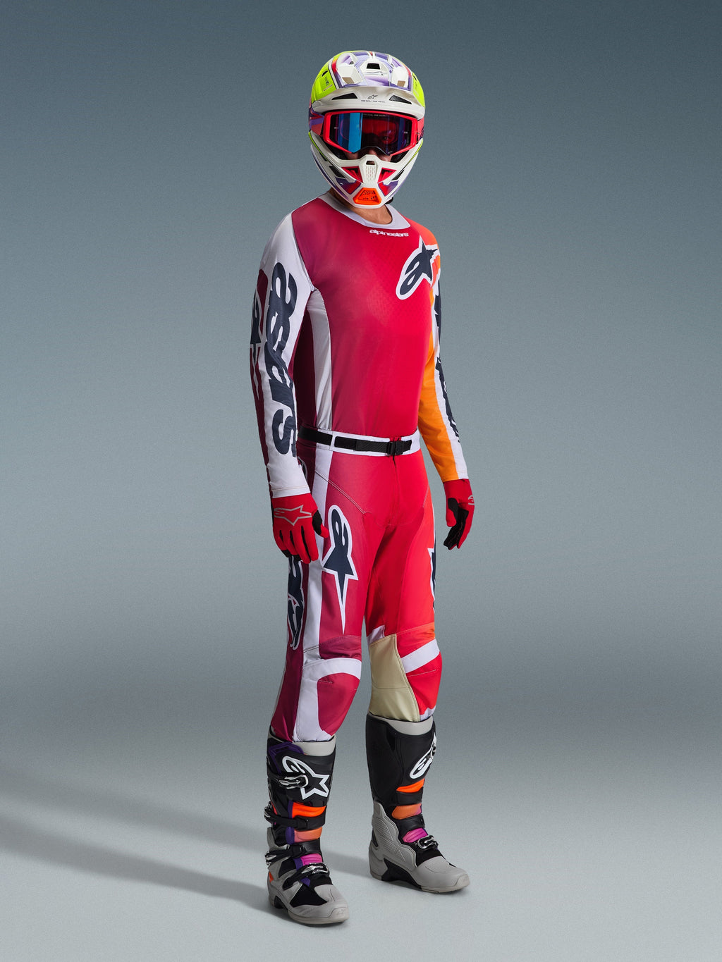 Alpinestars 2026 Racer Portl Pants, Motocross Pants, Red Light Gray and Dark Gray, worn as part of a full racing gear set with matching jersey, red gloves, colorful helmet with blue goggles, and gray boots, durable construction for off-road motocross performance.