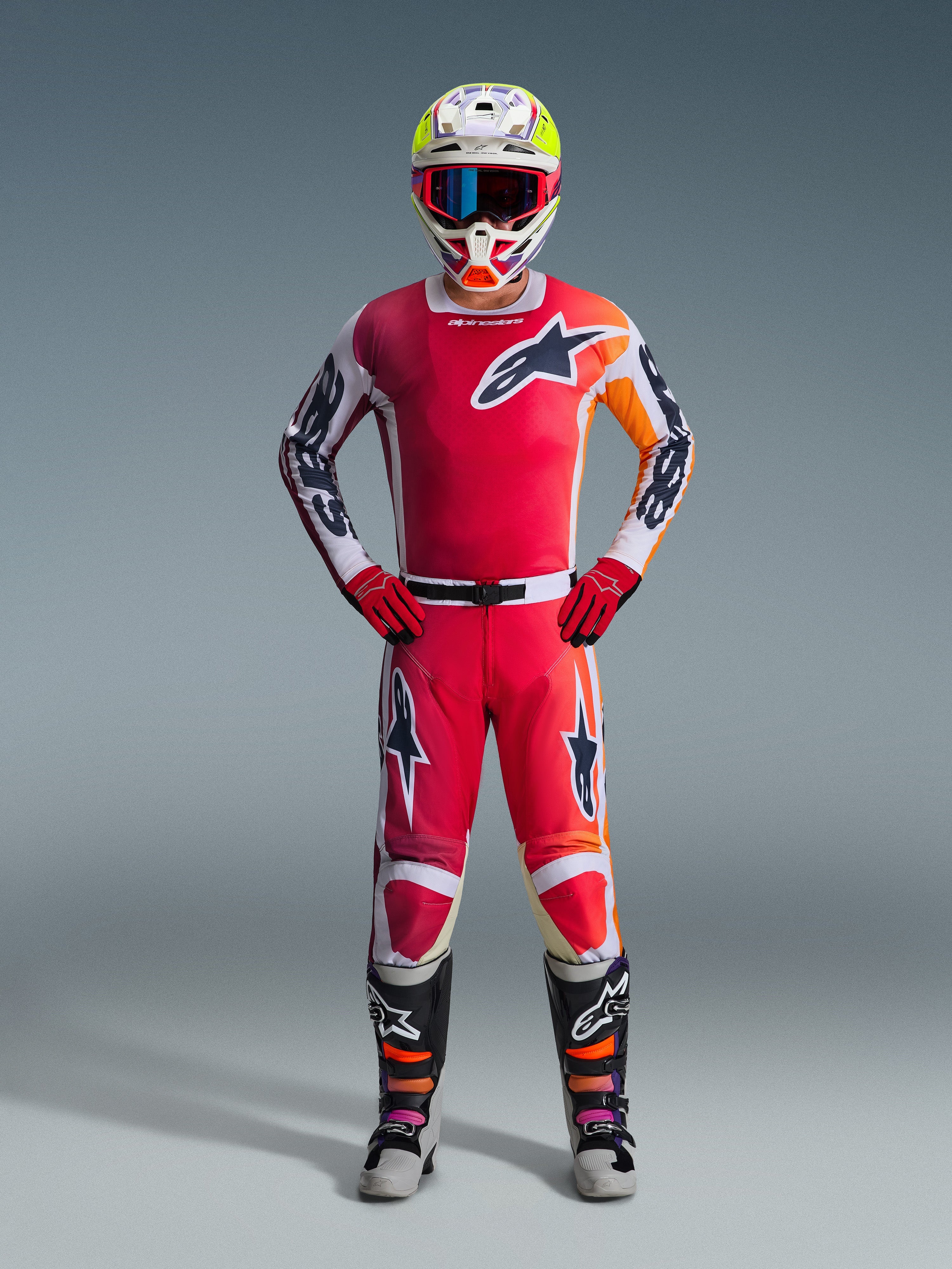 Alpinestars 2026 Racer Portl Gear Set, Motocross Outfit, Red and White, with orange and black accents, star logo on chest and legs, white helmet with yellow and purple details, red gloves, black boots with orange and purple highlights, complete MX gear ensemble