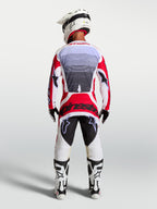 Alpinestars Techstar Maven motocross pants in Fire Red and White, rear view on a rider showing athletic race fit.