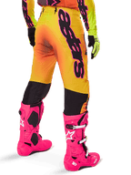 Alpinestars 2025 Supertech Lipan Gear Set, Rear view of yellow and orange gradient motocross pants with bold black branding, paired with bright pink Tech 10 boots and yellow gloves, professional off-road racing equipment