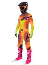 Alpinestars 2025 Supertech Lipan Pants, Motocross Pants, Yellow and Pink, worn as part of a full gear set with matching gradient jersey, bright pink boots, yellow gloves, and black helmet, featuring bold black logos and athletic fit for off-road racing