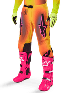Alpinestars 2025 Supertech Lipan Gear Set, Motocross Pants, Yellow and Orange gradient with Pink and Purple accents, featuring bold black Alpinestars logos on the thighs, worn with yellow gloves and bright pink motocross boots.