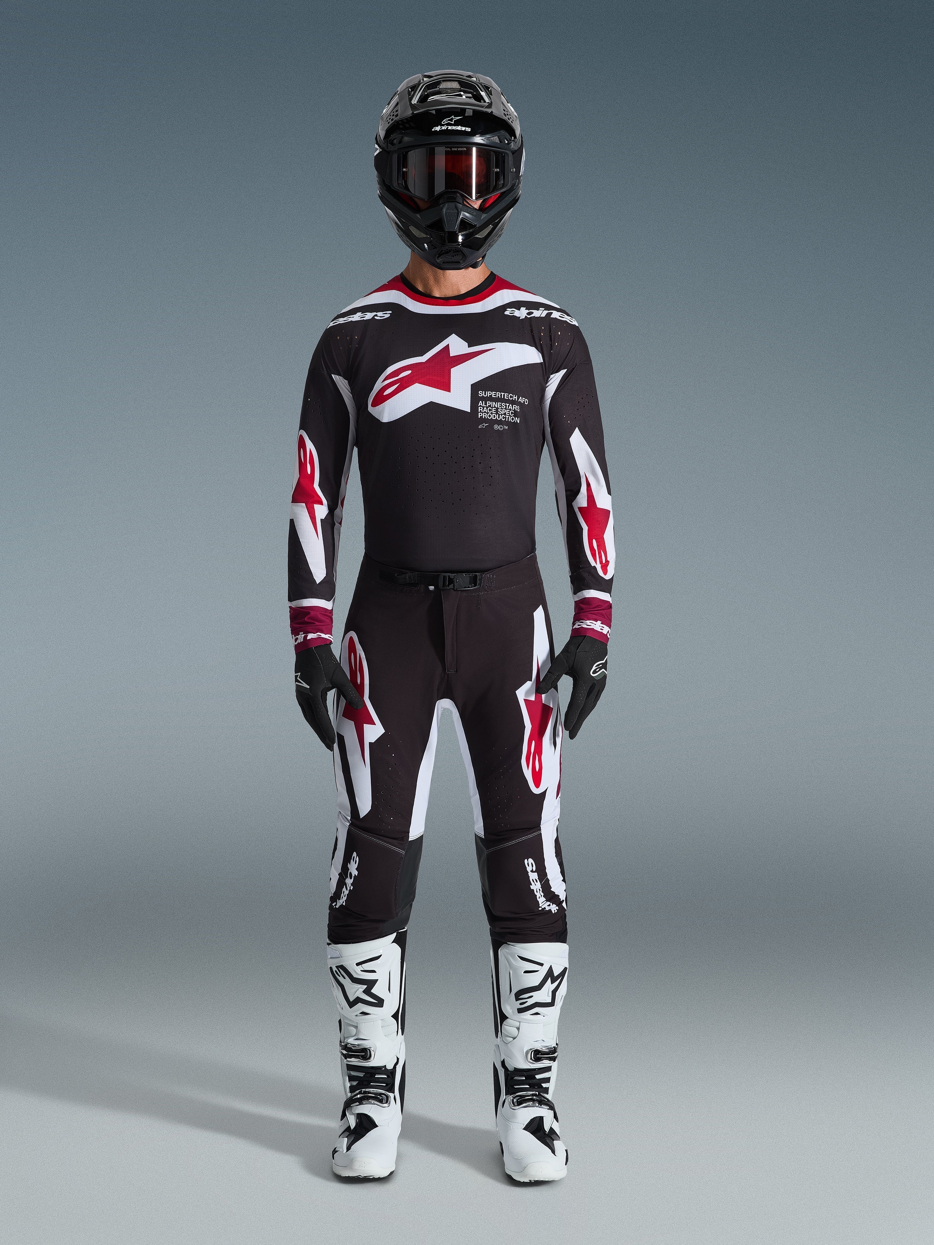 Alpinestars 2026 Supertech AFD Vista Pants, Motocross Pants, Black Red and White, worn as a complete racing gear set with matching jersey, black helmet, and white boots, featuring bold red and white Astars branding on the chest and legs, designed for elite off-road performance
