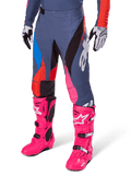 Alpinestars 2025 Techstar Dreem Pants, Motocross Pants, Dark Gray with Blue Red and Pink Panels, White Graphics, worn with bright pink boots and black and white gloves, bold high-visibility design
