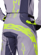 Alpinestars 2025 Techstar Dreem Pants, Motocross Pants, Gray and Dark Gray with fluorescent yellow accents, rear view showing bold Alpinestars branding across the yoke, worn with matching jersey and gloves, designed for off-road racing.