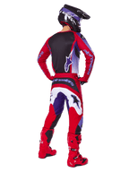 Motocross rider from behind wearing Alpinestars 2025 Fluid Wurx Pants, Purple Bright Red with white and black accents, matching jersey, black helmet, and red boots, coordinated outfit for off-road racing